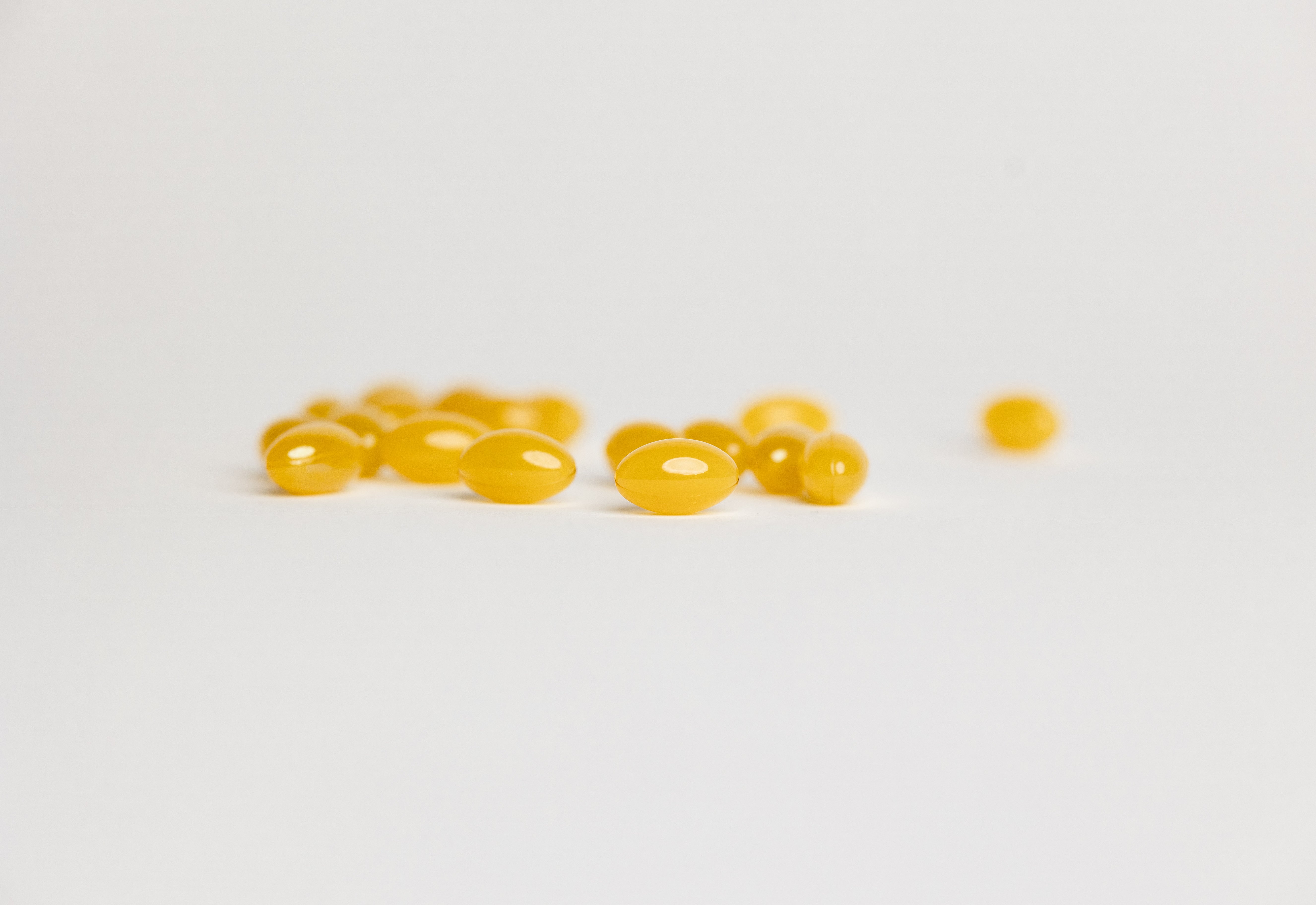 yellow softgels on white background