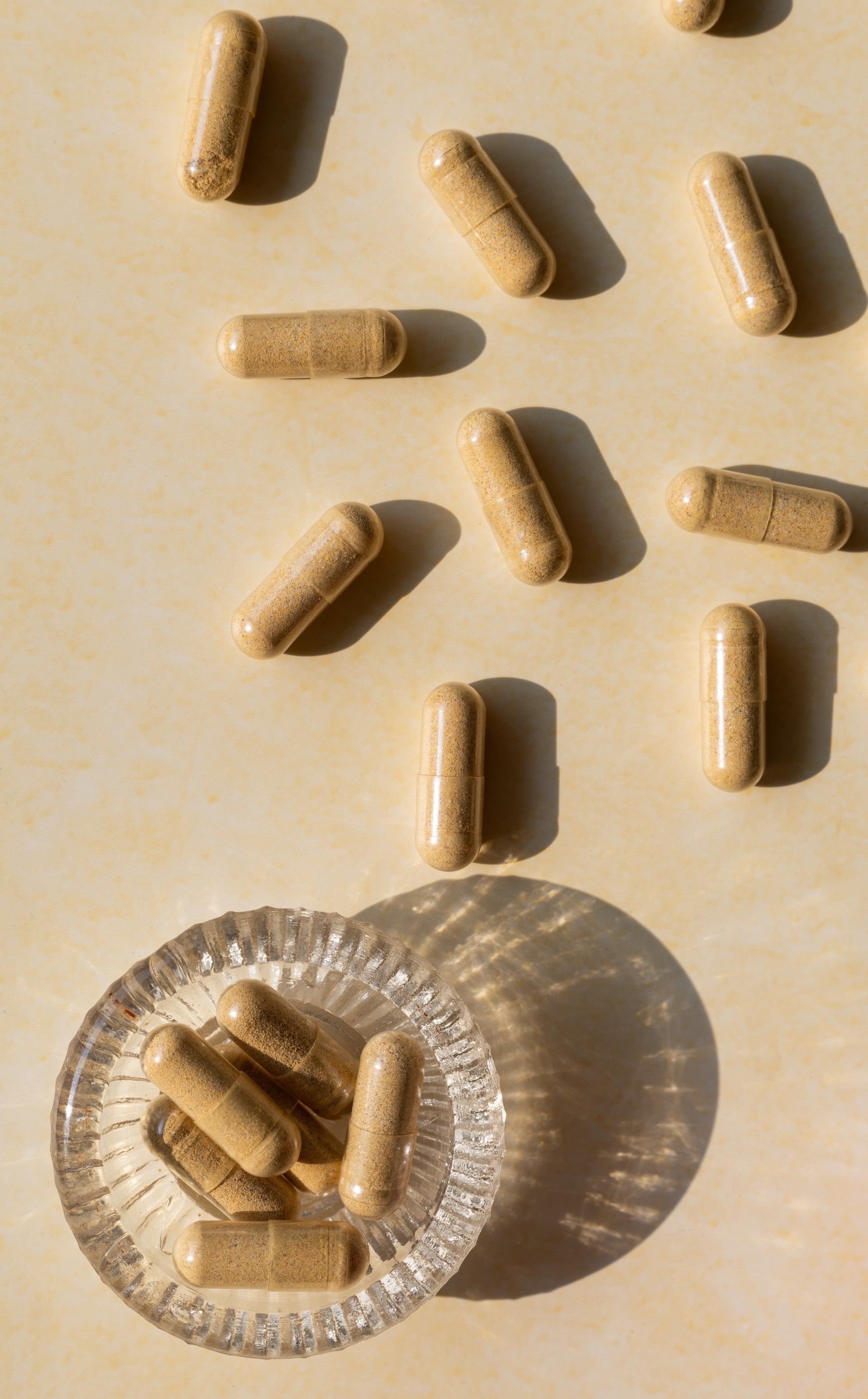 probiotic supplement capsules in glass dish and lying on table surface